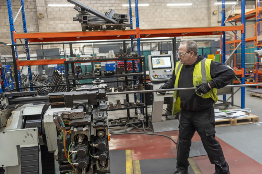 Photo of a worker using a tube bending machine at Kingsward Group