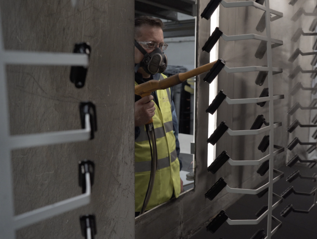 Photo of a worker using a powder coating equipment